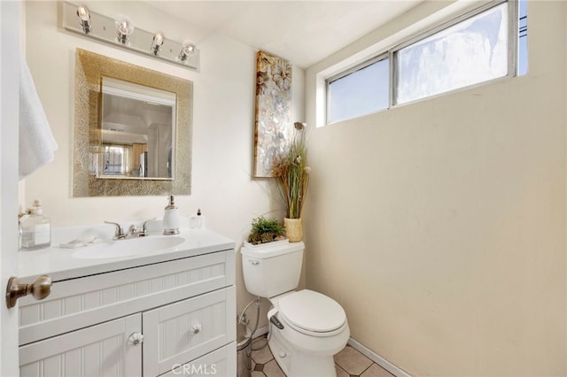 bathroom with tile patterned flooring, vanity, and toilet