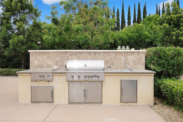 view of patio featuring grilling area, sink, and an outdoor kitchen