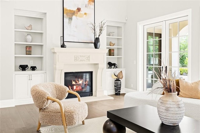 sitting room with built in shelves and light wood-type flooring