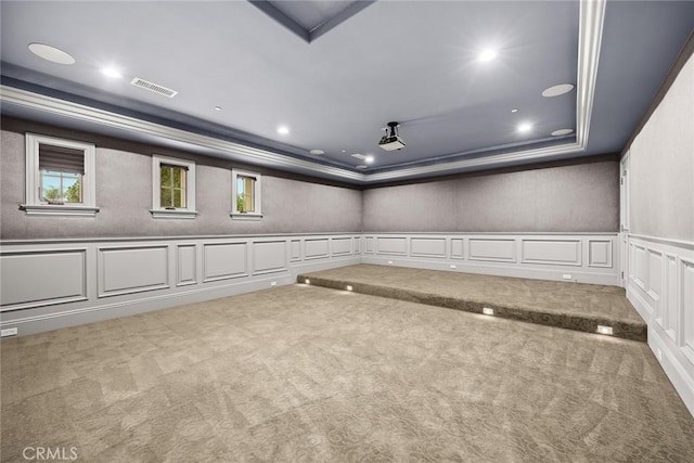 carpeted spare room with a tray ceiling and crown molding