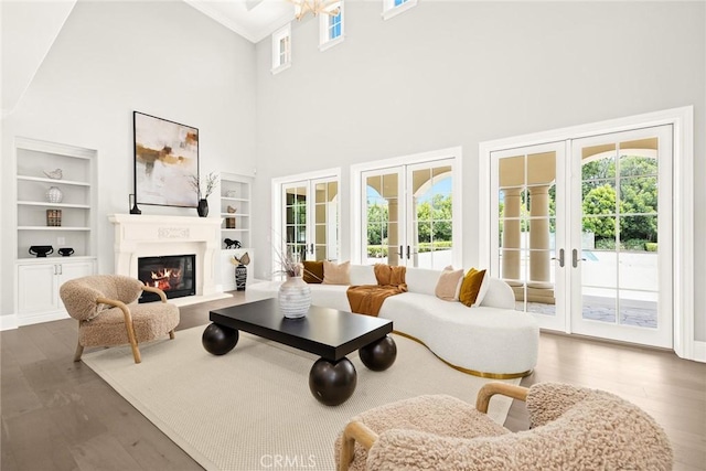 living room with a towering ceiling, french doors, dark hardwood / wood-style flooring, and built in features