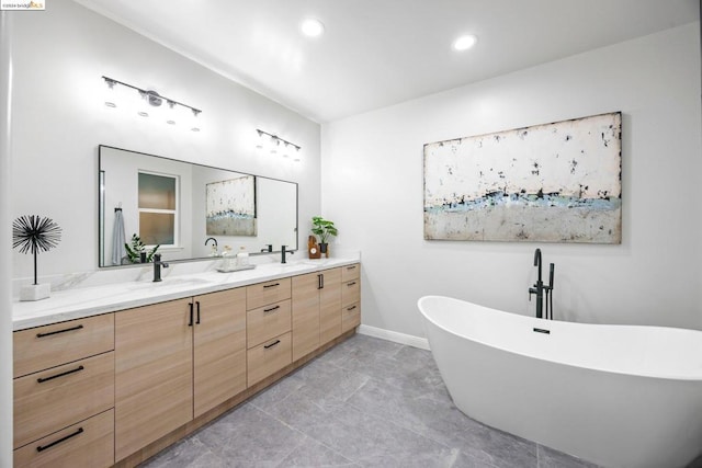 bathroom featuring a tub to relax in, tile patterned flooring, and vanity