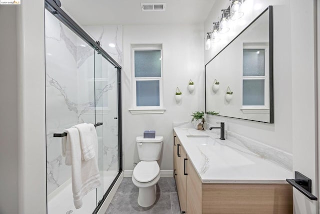 bathroom featuring tile patterned flooring, vanity, toilet, and a shower with shower door