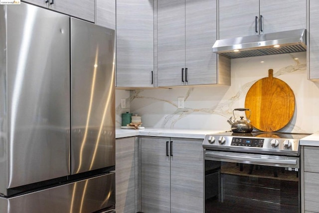 kitchen featuring tasteful backsplash, gray cabinetry, and appliances with stainless steel finishes