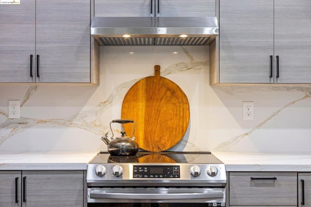 kitchen with gray cabinets, electric range, and extractor fan