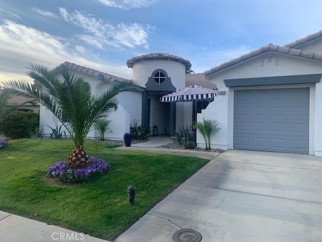 mediterranean / spanish-style home featuring a front lawn and a garage