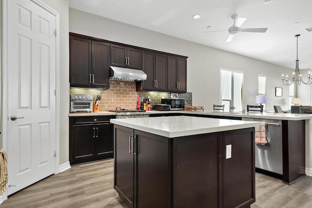 kitchen with dark brown cabinets, a kitchen island, light hardwood / wood-style floors, and decorative light fixtures