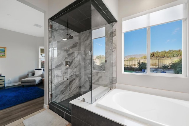 bathroom with wood-type flooring and independent shower and bath