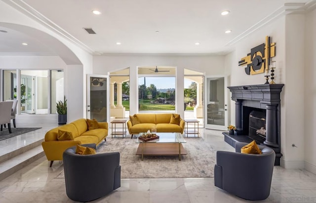 living room with ceiling fan and ornamental molding