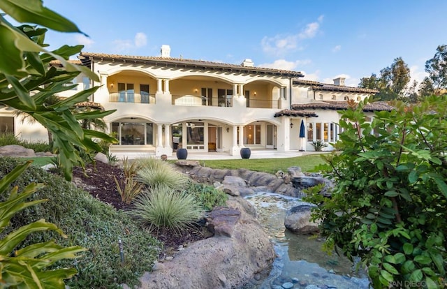 back of house featuring a balcony and a patio