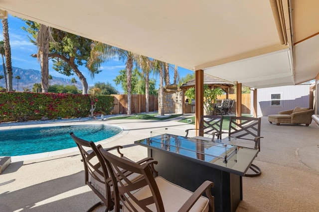 view of pool featuring a mountain view, a shed, and a patio area