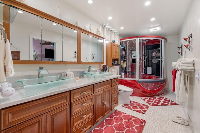 bathroom with vanity, toilet, and a shower with door