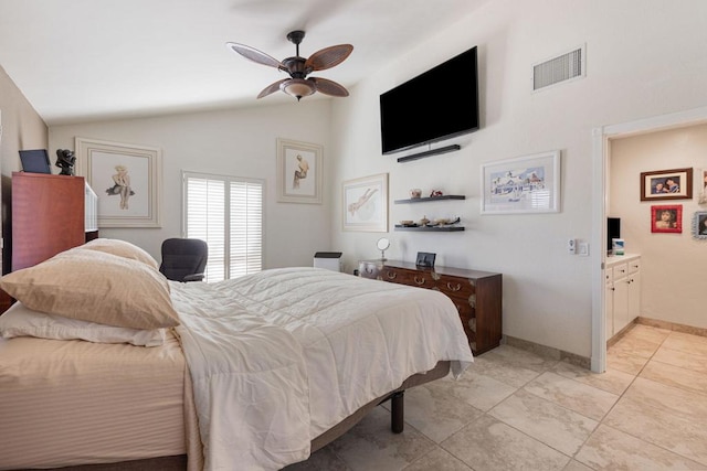 bedroom with ceiling fan, light tile patterned flooring, lofted ceiling, and connected bathroom