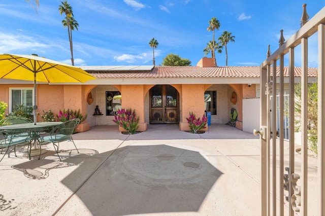 back of property featuring a patio area and solar panels