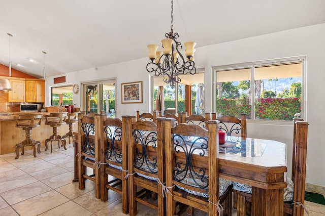 dining room with a wealth of natural light, light tile patterned floors, a chandelier, and vaulted ceiling