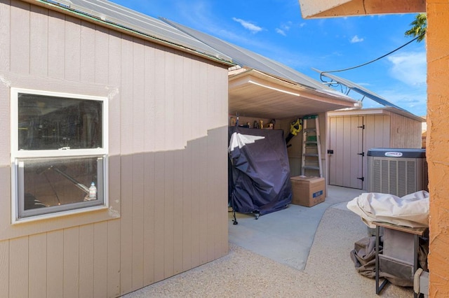 view of side of home with a patio, central AC, and a storage unit