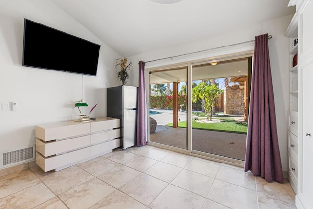 interior space featuring vaulted ceiling and light tile patterned flooring