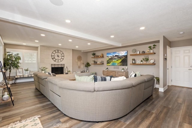 living room featuring beam ceiling, a fireplace, and dark hardwood / wood-style floors