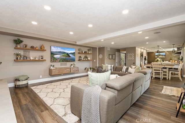 living room with beam ceiling, a textured ceiling, and dark hardwood / wood-style floors