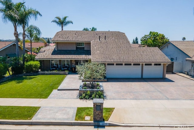 view of front of home with a garage and a front lawn