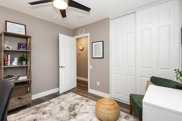 home office with ceiling fan and dark hardwood / wood-style flooring