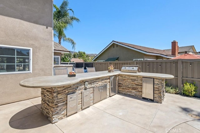 view of patio with a grill, exterior kitchen, and an outdoor bar