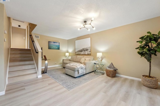 living room featuring a textured ceiling and light hardwood / wood-style flooring