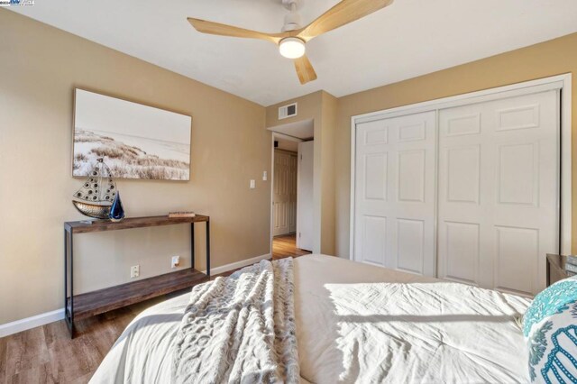 bedroom with hardwood / wood-style floors, ceiling fan, and a closet