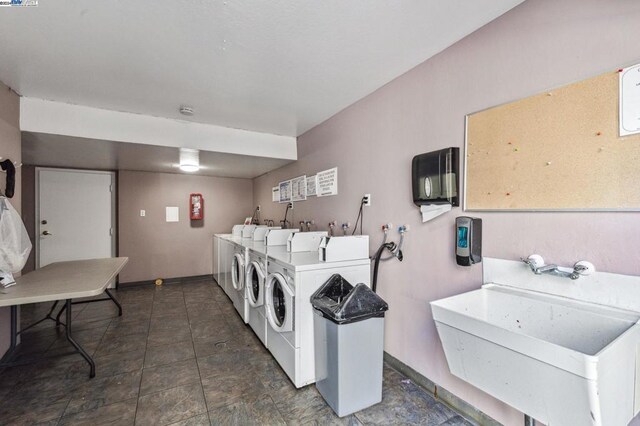 clothes washing area with washing machine and dryer and sink