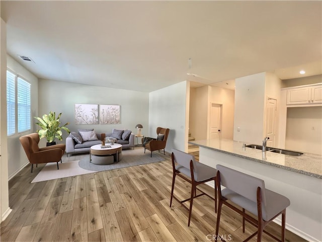 living room with light hardwood / wood-style flooring and sink