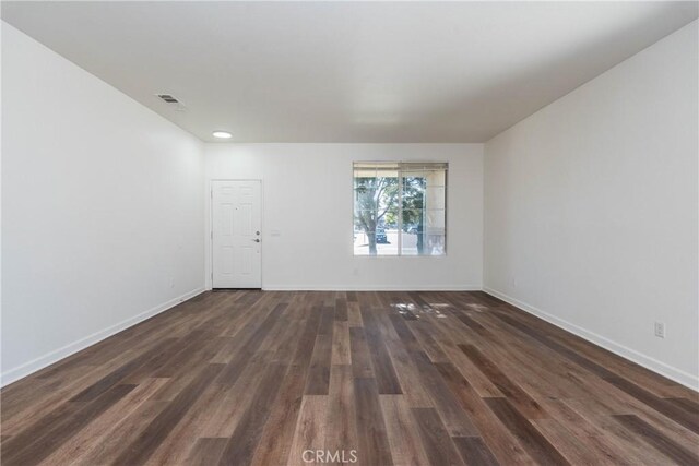 spare room with dark wood-type flooring