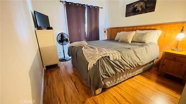 bedroom featuring wood walls and wood-type flooring