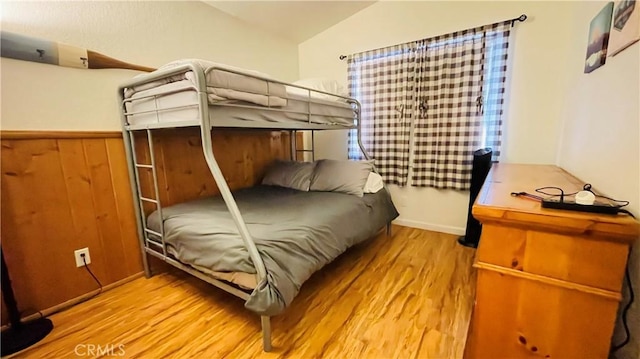 bedroom featuring light wood-type flooring and vaulted ceiling