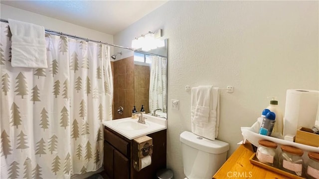 bathroom with toilet, vanity, and walk in shower