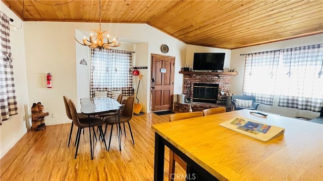 dining space featuring hardwood / wood-style floors, wooden ceiling, a fireplace, and vaulted ceiling