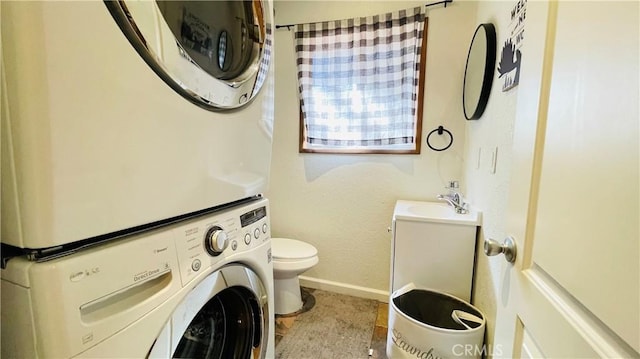 laundry area featuring sink, light tile patterned floors, and stacked washer and clothes dryer