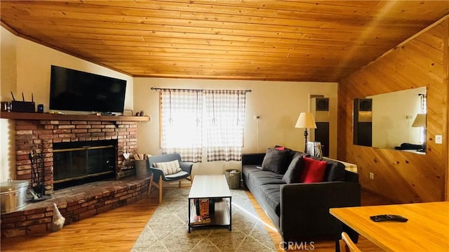 living room with a brick fireplace, wood walls, light hardwood / wood-style floors, vaulted ceiling, and wood ceiling