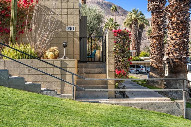 property entrance with a mountain view and a yard