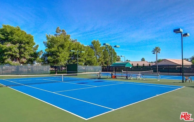 view of tennis court featuring basketball hoop