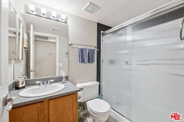 bathroom featuring vanity, toilet, and an enclosed shower