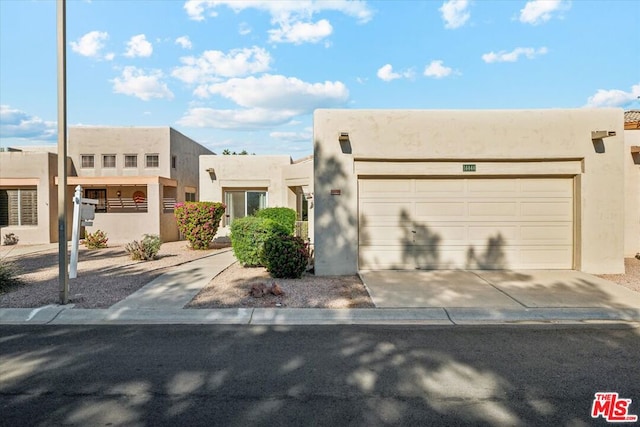 pueblo-style home with a garage