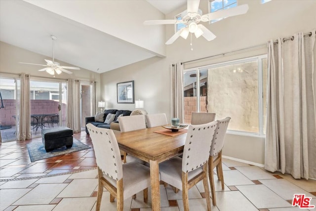 dining room with ceiling fan, lofted ceiling, and a fireplace