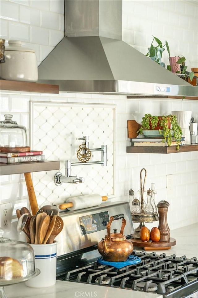 kitchen with stainless steel range with gas cooktop, ventilation hood, and tasteful backsplash