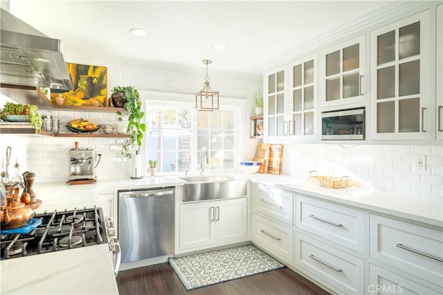 kitchen featuring light stone counters, white cabinetry, appliances with stainless steel finishes, and hanging light fixtures