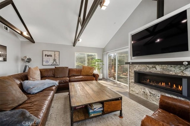 living room with a fireplace and vaulted ceiling with beams