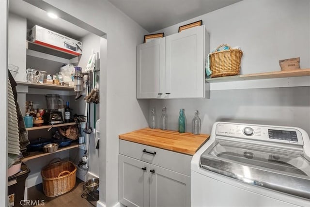 laundry room featuring washer / dryer and cabinets