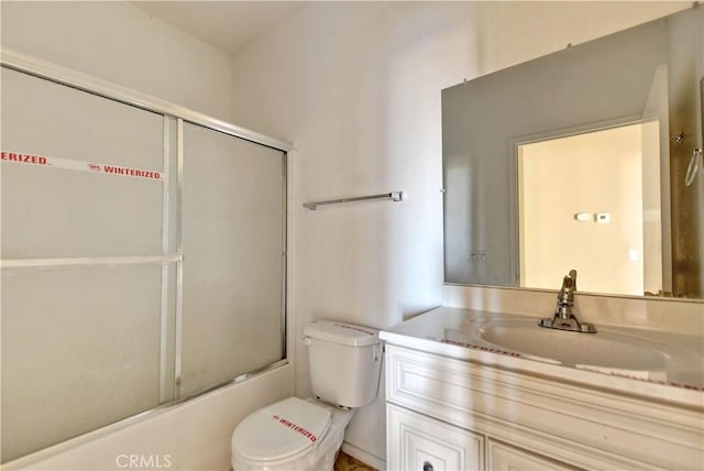 full bathroom featuring vanity, toilet, and combined bath / shower with glass door