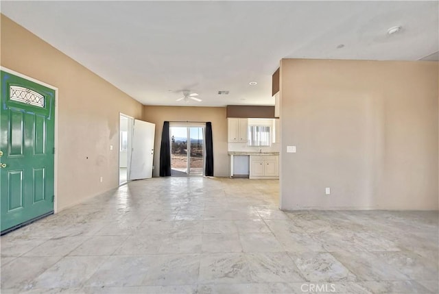 unfurnished living room featuring ceiling fan