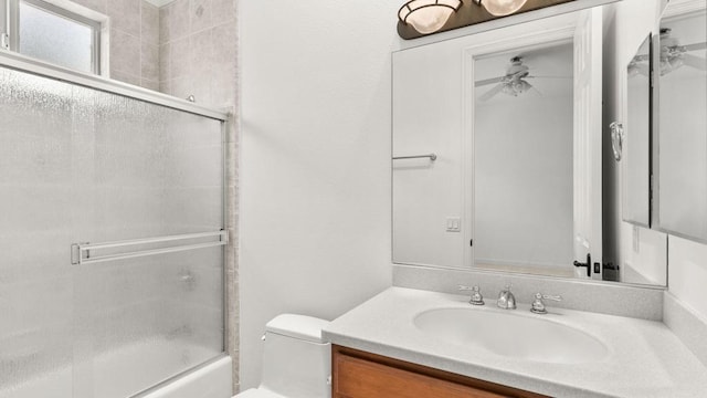 full bathroom with vanity, ceiling fan, toilet, and enclosed tub / shower combo