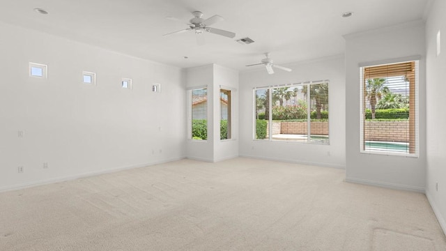 spare room with plenty of natural light, ornamental molding, and light carpet